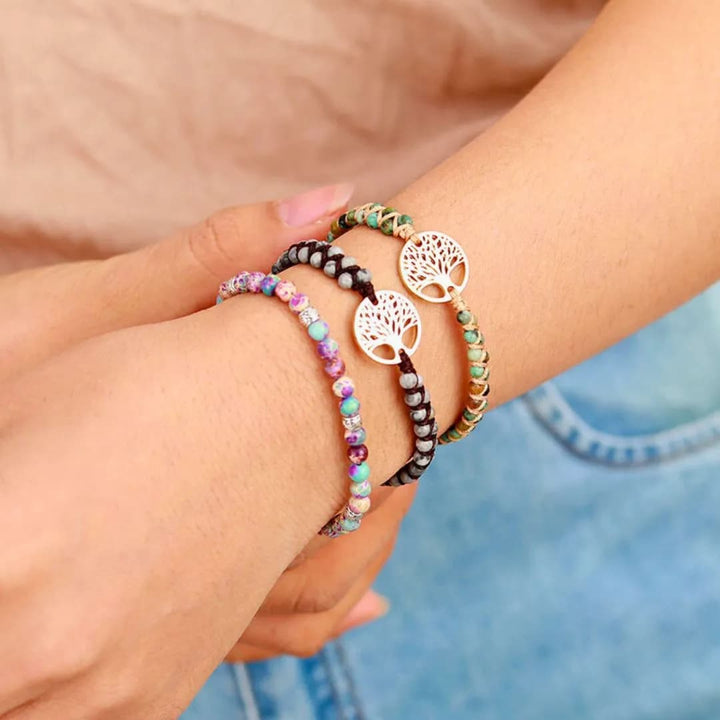 Vista lateral da pulseira de pedra com design trançado e pingente Árvore da Vida, ideal para adicionar um toque de sofisticação ao look feminino.