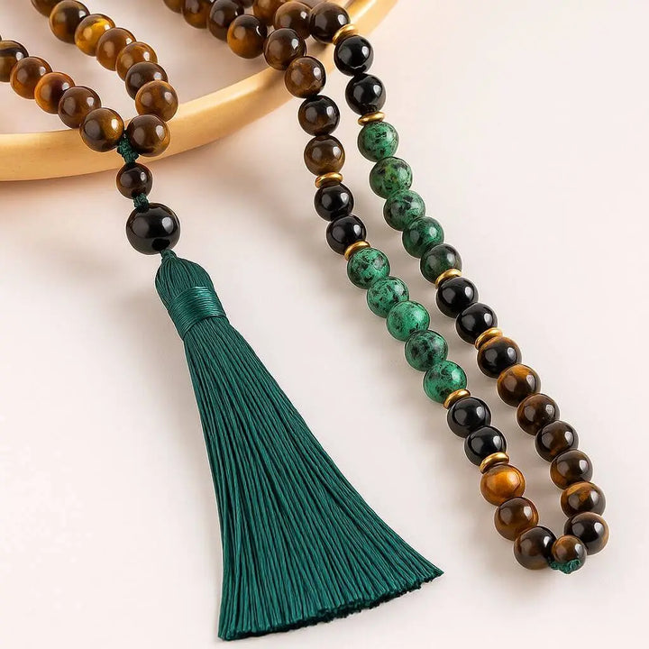 Detalhe das contas do Japamala de Olho de Tigre, Turquesa Africana e Ônix Negra, mostrando a combinação perfeita para proteção e clareza mental durante a meditação.