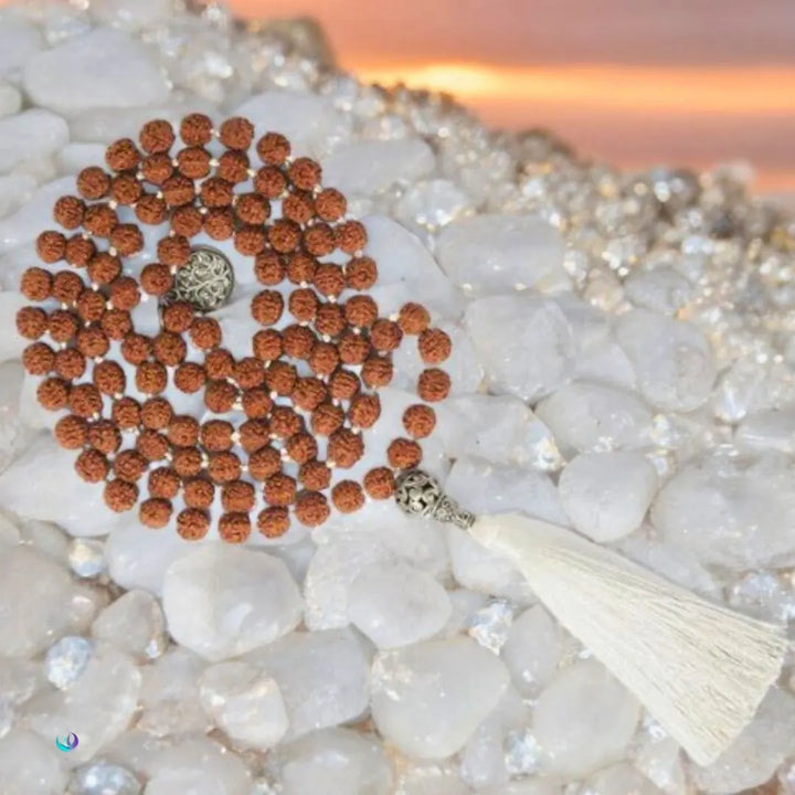 Japamala de Semente de Rudraksha sobre pedras brancas, criando um ambiente de paz e harmonia, ideal para meditação profunda.