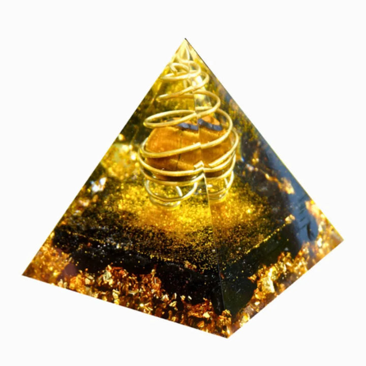 Orgonite Pirâmide com Olho de Tigre e Turmalina Negra em fundo branco, mostrando a estrutura interna com espiral dourado.