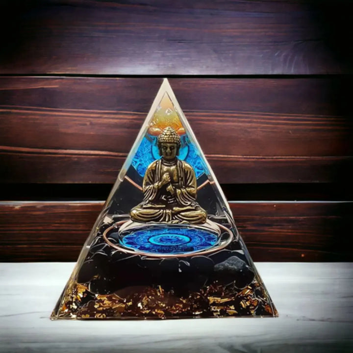 Orgonite Pirâmide Buda Meditação com Quartzo Negro, destacando a figura de Buda meditando dentro da pirâmide com fundo de madeira.